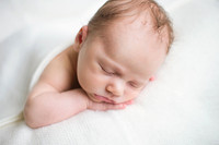 Newborn baby sleeping on a white blanket
