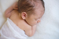 Newborn baby sleeping on a white blanket