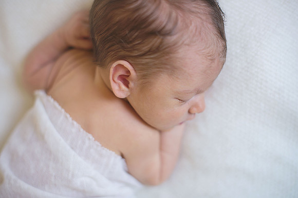 Newborn baby sleeping on a white blanket